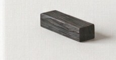 A single charred wooden block, resting on linen