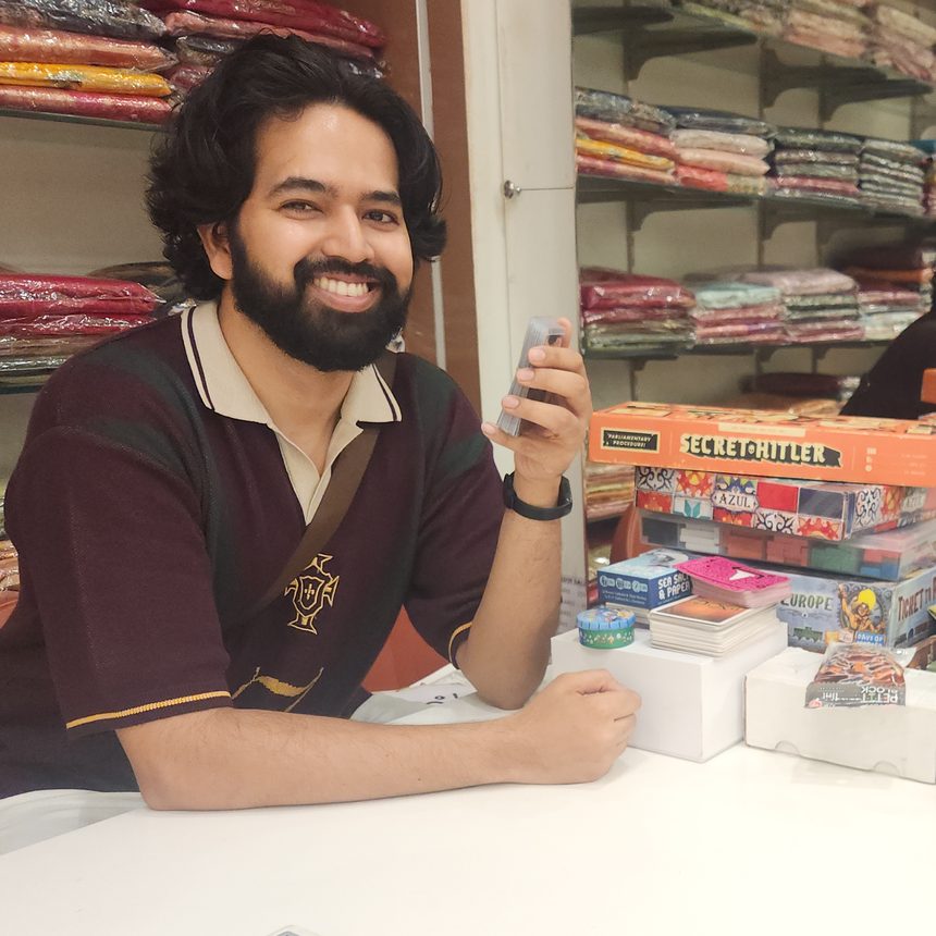 Sora Kalden grinning across a table stacked with board games